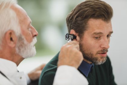 Lekarz bada mężczyźnie uszy