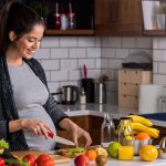 Kobieta w ciąży kroi warzywa