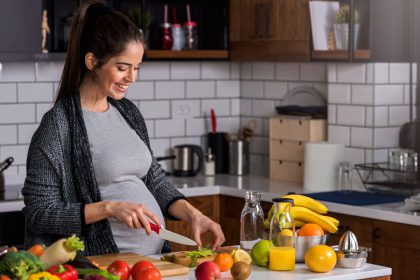 Kobieta w ciąży kroi warzywa
